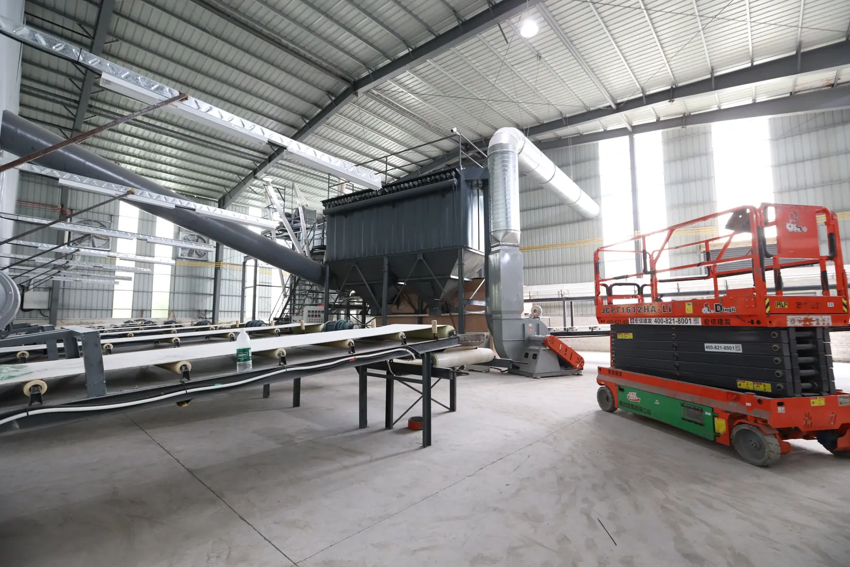 Photograph of conveyors and material-processing equipment in a naturally lit workshop